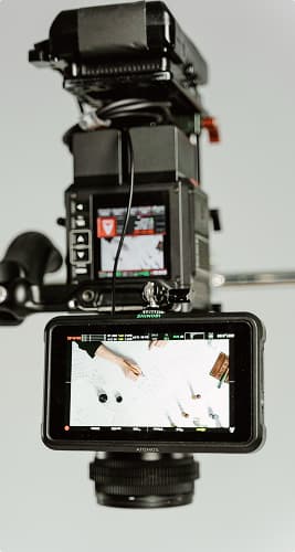 Close-up of a professional video camera monitor showing a top-down view of a desk