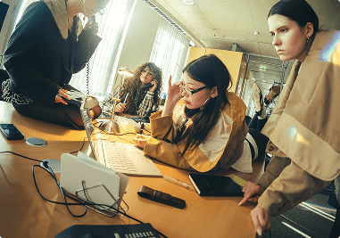 Creative team collaborating and reviewing work on a laptop