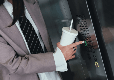Person in a suit holding a white coffee cup