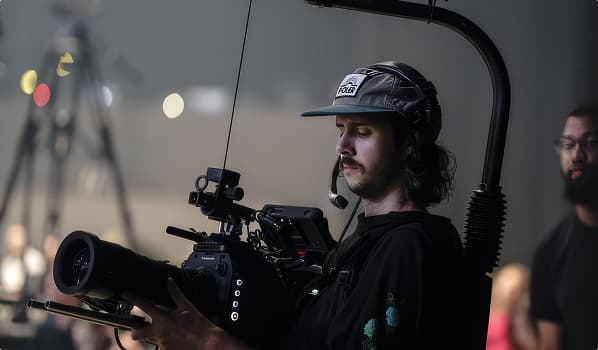 Camera operator filming with a professional cinema camera in a studio