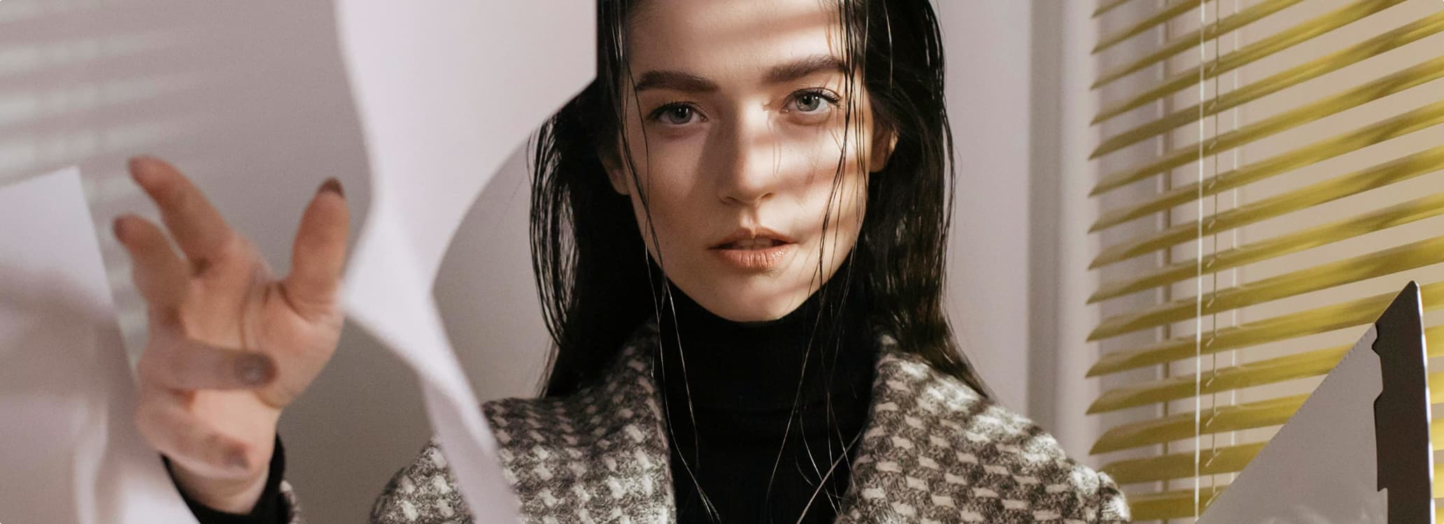 Portrait of a woman with wet hair and a blazer with blurred papers in the foreground